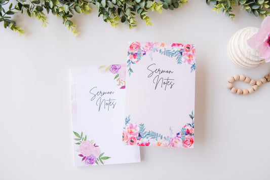 Floral notebook labeled 'Sermon Notes' on a light surface with greenery and decorative items.