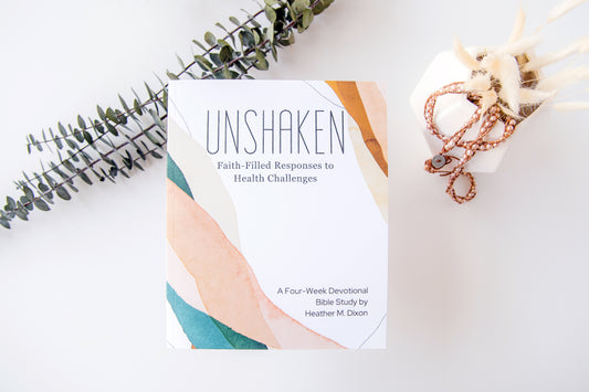 Book titled 'Unshaken' on a white surface with decorative elements